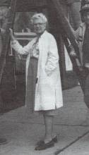 Betty Van Newkirk standing outside in front of a ladder