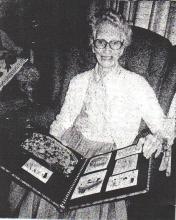 Photo of Agnes Carroll holding a book that is opened