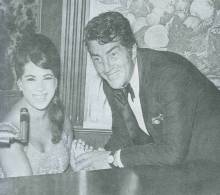 Alice Darr and entertainer Dean Martin pose in front of piano