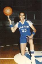 Photo of girl on basketball court on 1 knee with basketball on fingers; Marsha Williams-Vickers