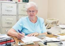 Photo of Gloria Martin at desk writing 
