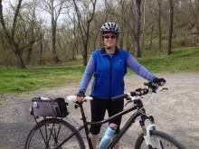 Photo of Betsey Hurwitz-Schwab at park standing with bike and wearing helmet