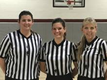 Photo of 3 women referees at basketball game, pose for picture