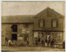 Little Country store with horse outside and people standing near front entrance