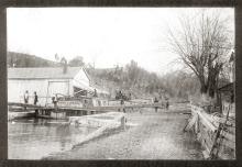 Loaded canal boat at the Williamsport Lock (Lock 44); building near lock with several men about in the area
