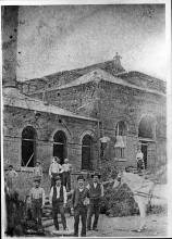 Electric Power Station in Williamsport being built; man on roof, several men outside working, 1 horse in photo