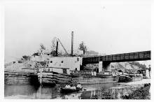 Equipment at the Cushwa wharf; Boat in canal with 3 people in small row boat