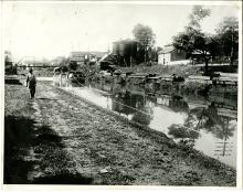 Canal at Hancock; boat in canal with rope, man along walkway