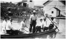 8 people in row boat, 1 person standing; Taylor family at Lock 49