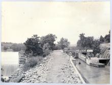 The wall of Dam 5, the basin below the lock; boat in canal