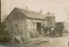 Photograph of blacksmith's barn with horse and book wagon at barn door