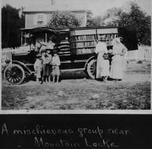 Book wagon with group of young children talking and 3 women looking through books