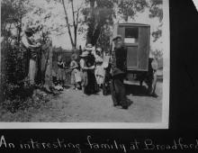 Bookwagon visiting family; children and family looking at books on wagon