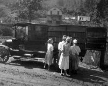 Book wagon on country road; women and children looking through books