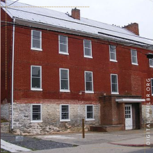 Almshouse icon; red brick building with stone basement exposed